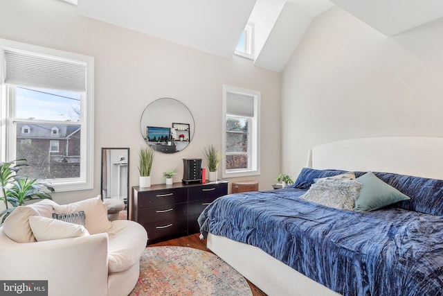 bedroom with hardwood / wood-style flooring and lofted ceiling with skylight