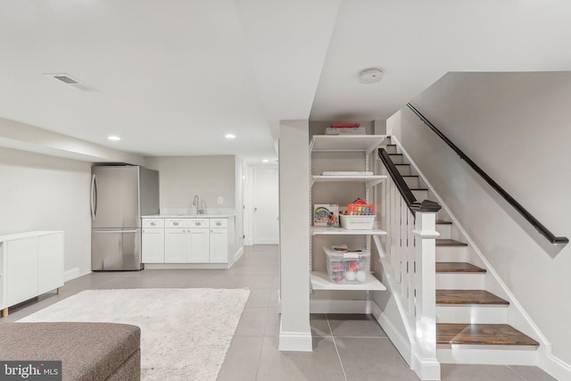 stairs with tile patterned flooring and sink