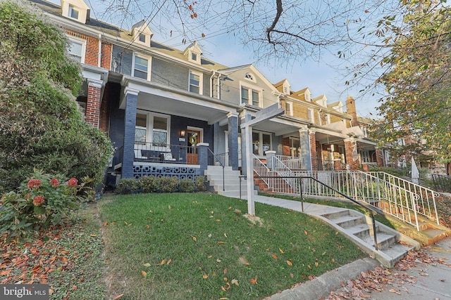 townhome / multi-family property with covered porch and a front lawn