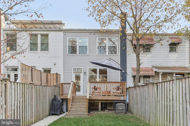 rear view of house with central AC unit and a wooden deck