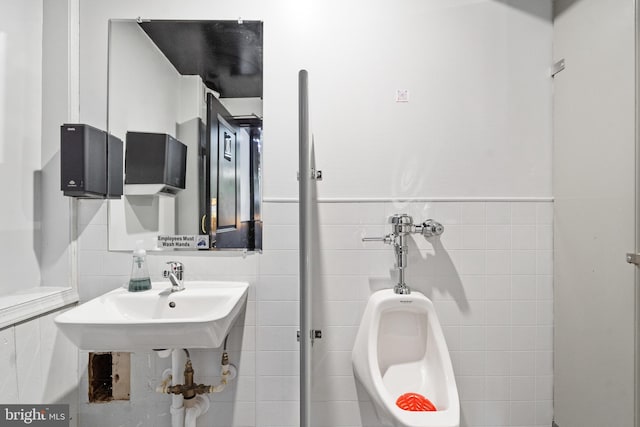 bathroom featuring sink and tile walls