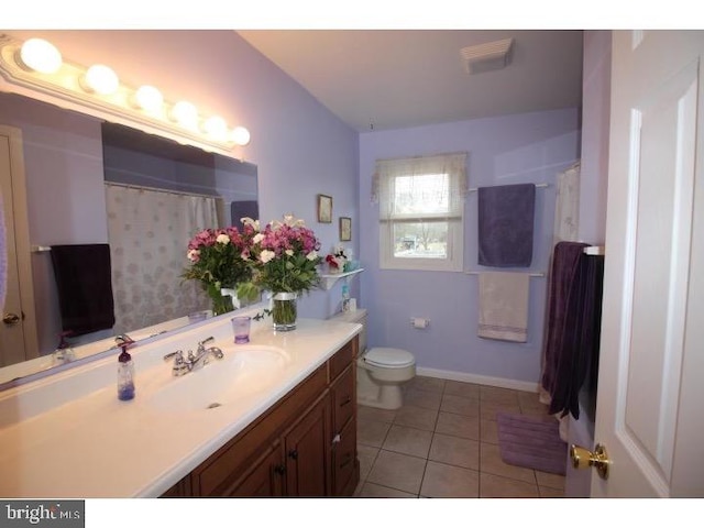 bathroom featuring tile patterned flooring, vanity, and toilet