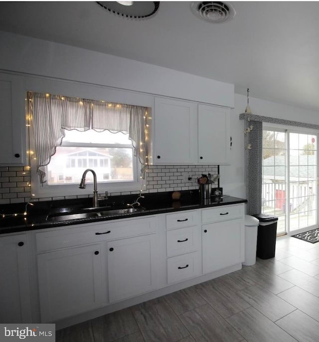 kitchen featuring white cabinets, sink, and tasteful backsplash