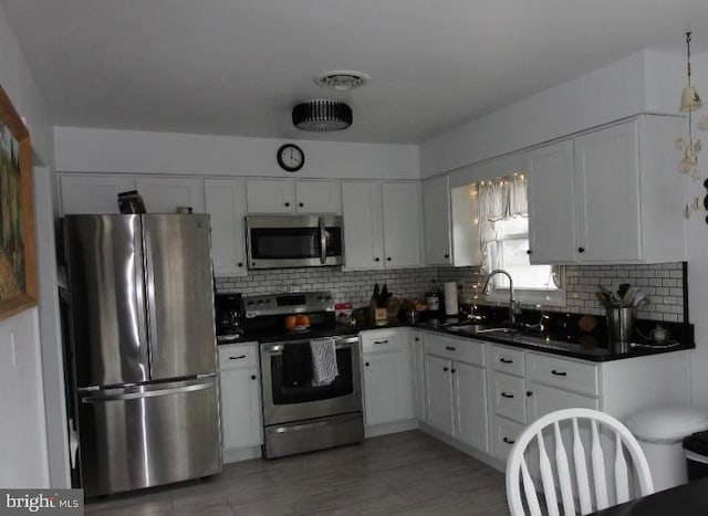 kitchen with white cabinets, decorative backsplash, sink, and appliances with stainless steel finishes