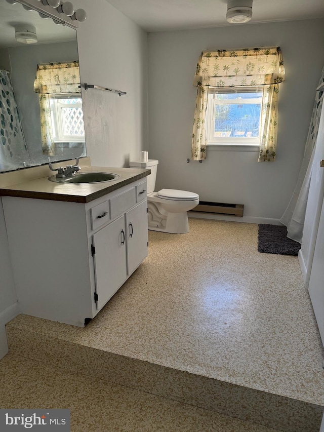 bathroom featuring baseboard heating, vanity, and toilet