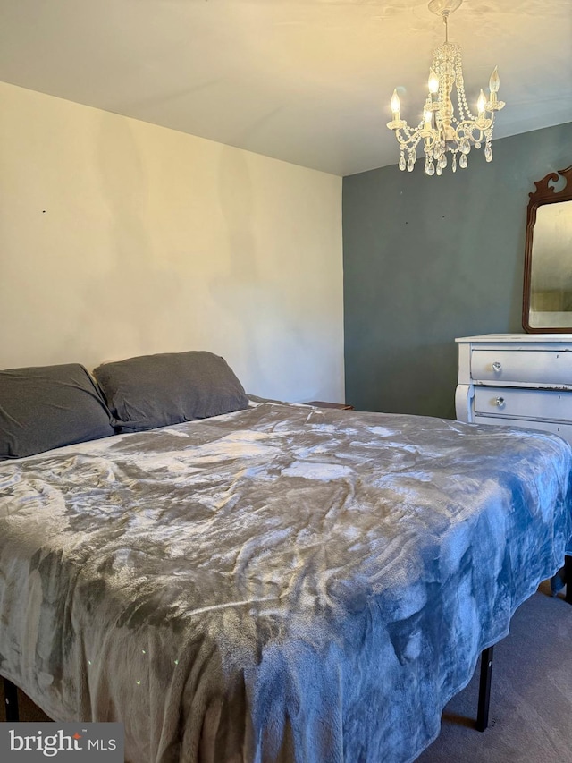 carpeted bedroom with an inviting chandelier