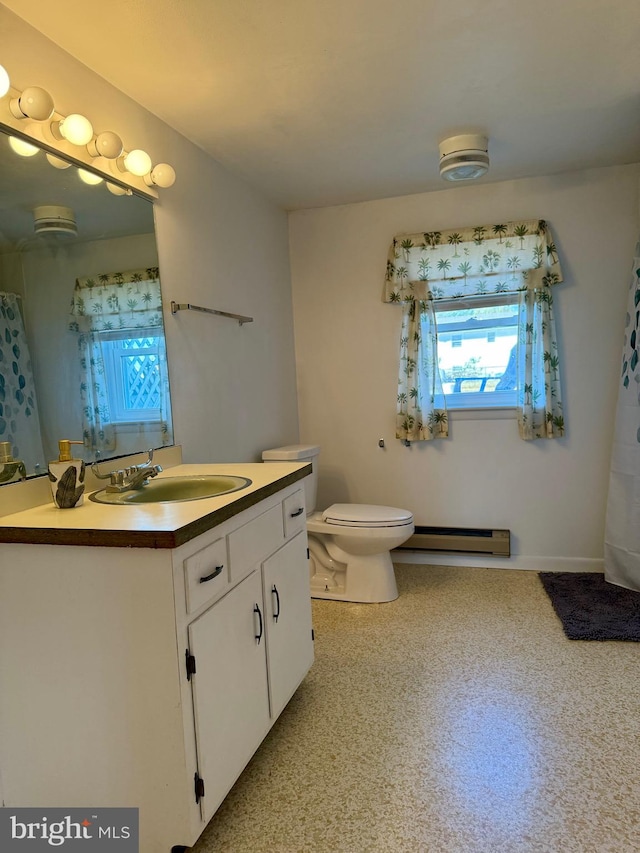 bathroom featuring vanity, toilet, and a baseboard heating unit