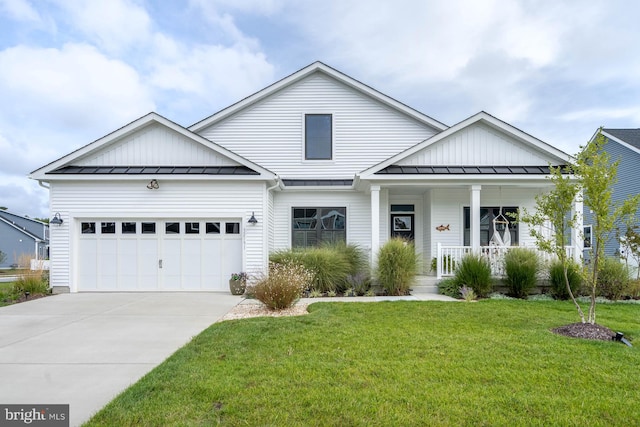 view of front facade with a garage, a front lawn, and covered porch