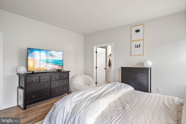 bedroom with light hardwood / wood-style floors and connected bathroom