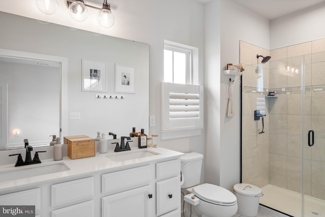 bathroom with a shower with door, vanity, and toilet