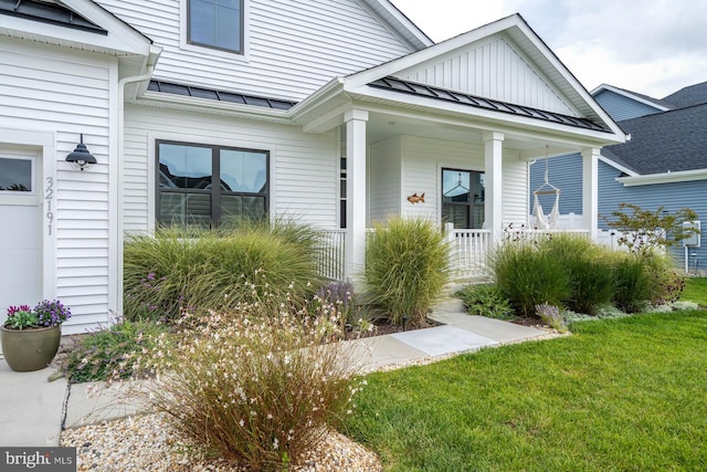 property entrance with a yard and covered porch