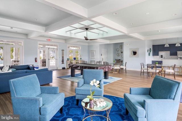 living room with french doors, beamed ceiling, wood-type flooring, and ceiling fan