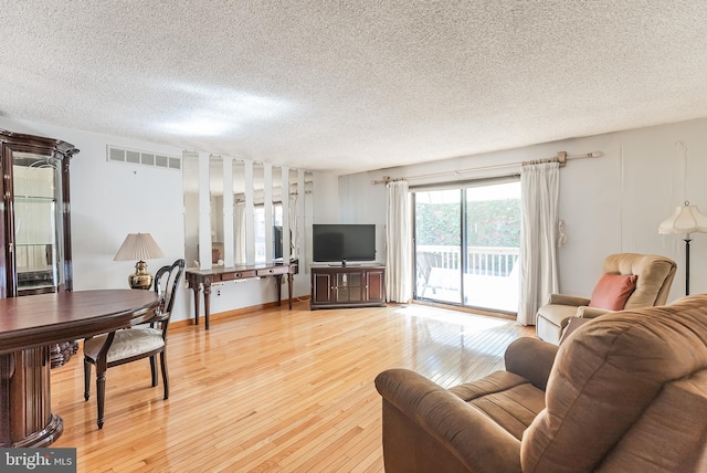 living room with hardwood / wood-style floors and a textured ceiling