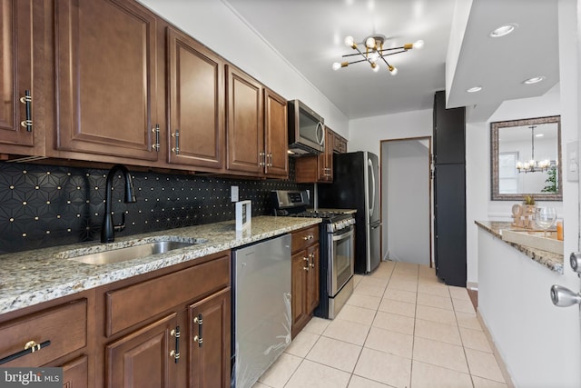 kitchen with a chandelier, appliances with stainless steel finishes, backsplash, and sink