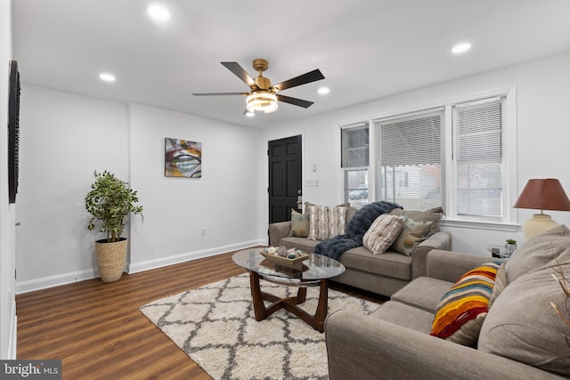 living room with ceiling fan and dark hardwood / wood-style flooring