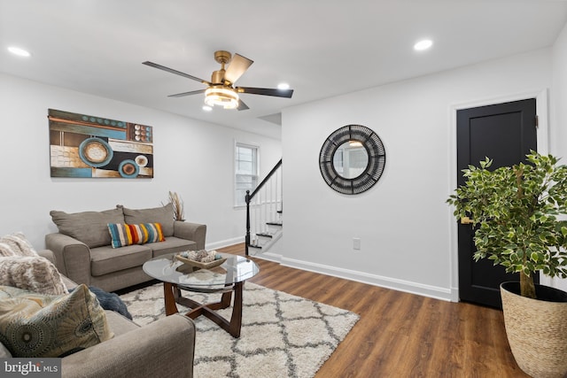 living room featuring ceiling fan and dark hardwood / wood-style floors