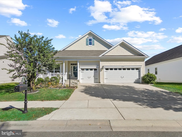 view of front of property with covered porch, a front yard, and a garage