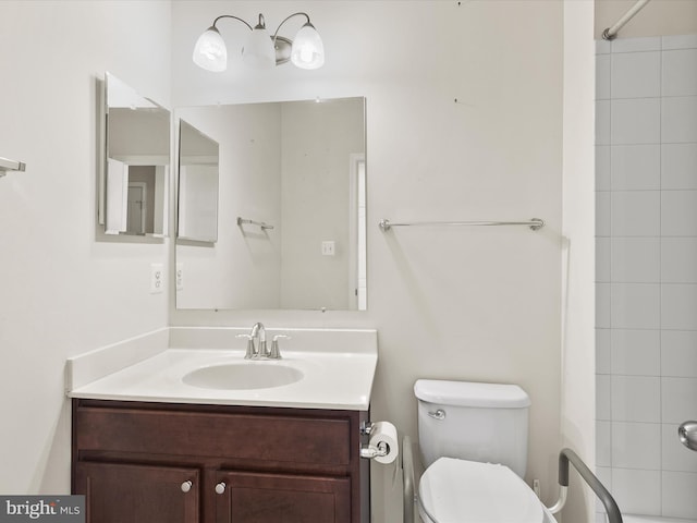 bathroom featuring vanity, toilet, and tiled shower