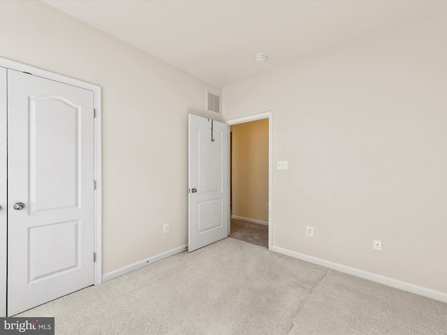 unfurnished bedroom featuring light carpet