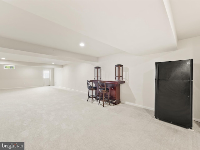 interior space with light carpet, indoor bar, and black refrigerator