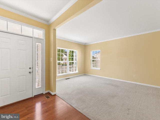 foyer entrance featuring crown molding and hardwood / wood-style flooring