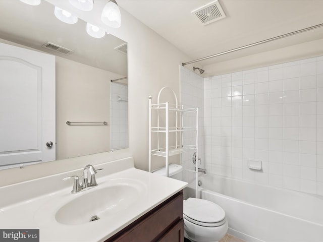 full bathroom featuring vanity, tiled shower / bath combo, and toilet