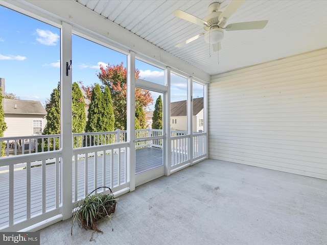 unfurnished sunroom with ceiling fan