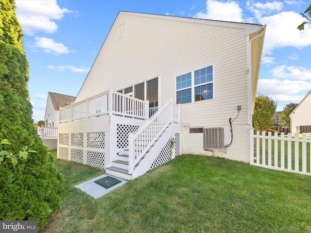 rear view of property featuring a yard, a deck, and central AC unit