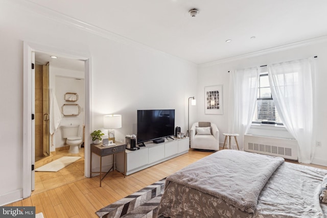 bedroom with light hardwood / wood-style floors, crown molding, radiator heating unit, and ensuite bathroom