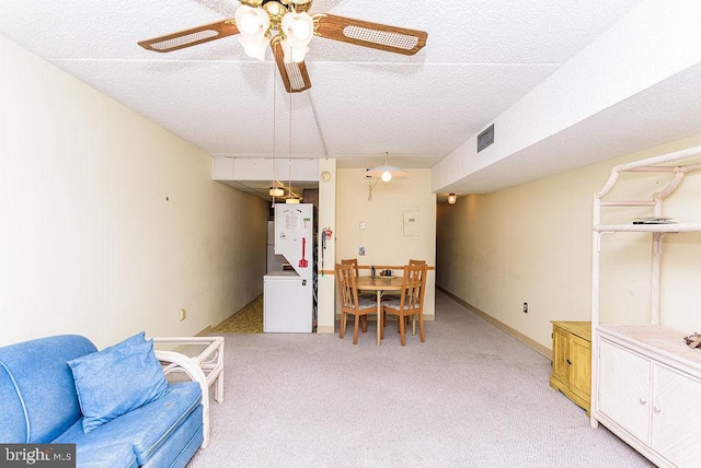 dining area with light carpet, a textured ceiling, and ceiling fan