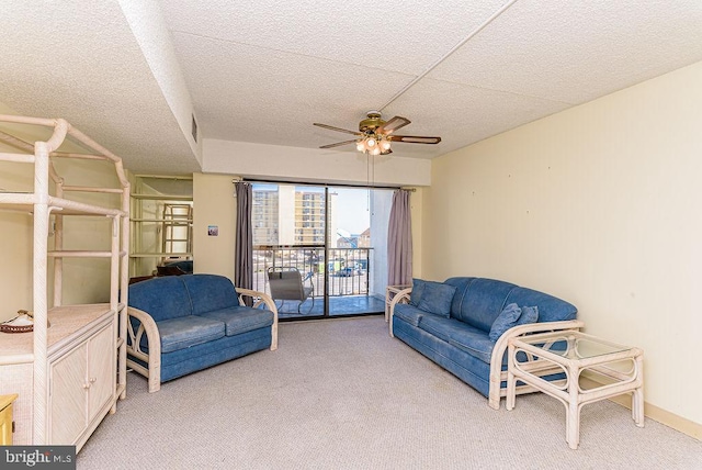 living room featuring light carpet, a textured ceiling, and ceiling fan