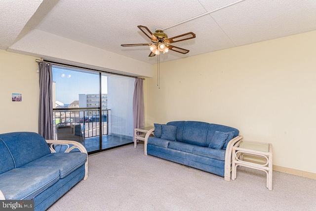 carpeted living room with a textured ceiling and ceiling fan