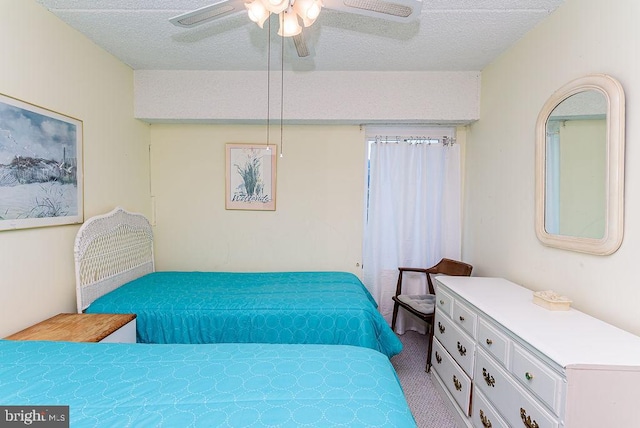 carpeted bedroom featuring ceiling fan and a textured ceiling