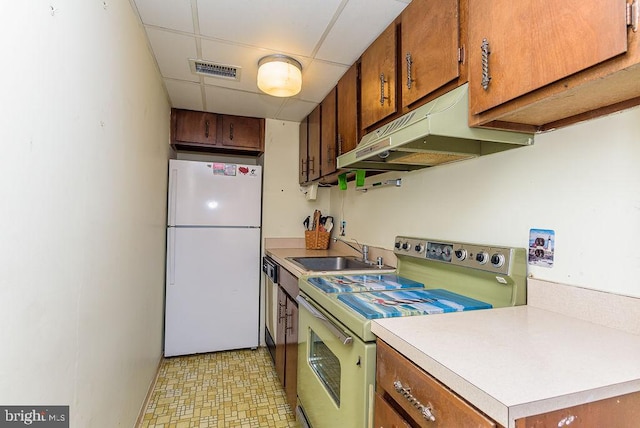 kitchen with a drop ceiling, sink, and white appliances