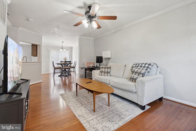 living room with ornamental molding, hardwood / wood-style floors, and ceiling fan