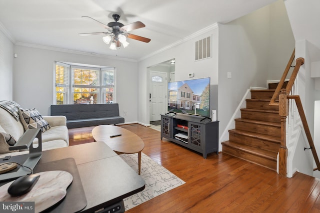 living room featuring ceiling fan, wood-type flooring, and ornamental molding