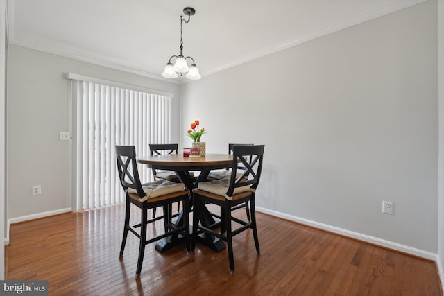 dining space featuring an inviting chandelier, ornamental molding, and dark hardwood / wood-style flooring