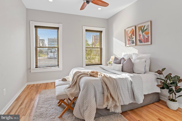 bedroom featuring light wood-type flooring, multiple windows, and ceiling fan