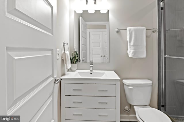 bathroom featuring an enclosed shower, vanity, and toilet