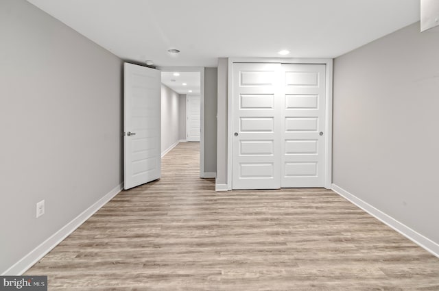 unfurnished bedroom with light wood-type flooring and a closet