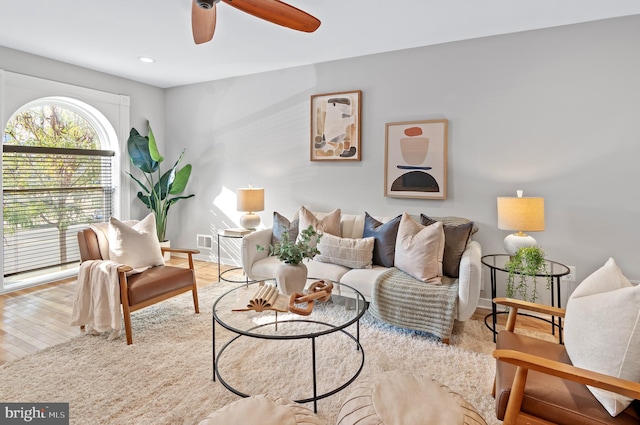 living room featuring light hardwood / wood-style flooring and ceiling fan