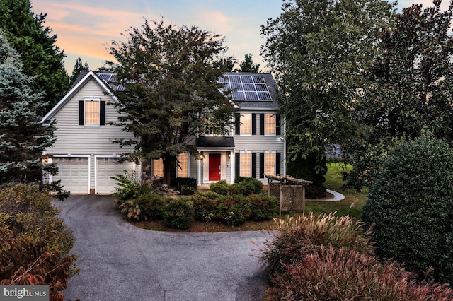 view of front facade with solar panels and a garage