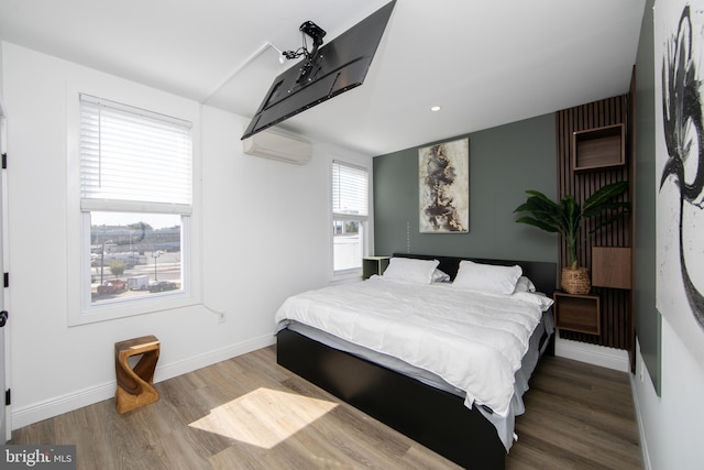 bedroom featuring a wall mounted air conditioner and wood-type flooring