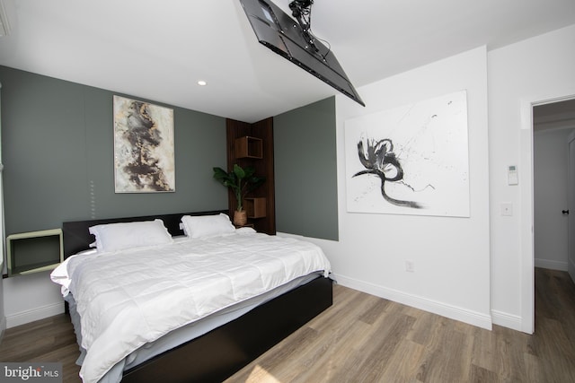 bedroom featuring an AC wall unit and hardwood / wood-style flooring