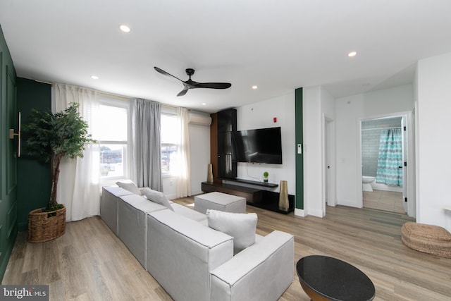 living room featuring light hardwood / wood-style floors and ceiling fan