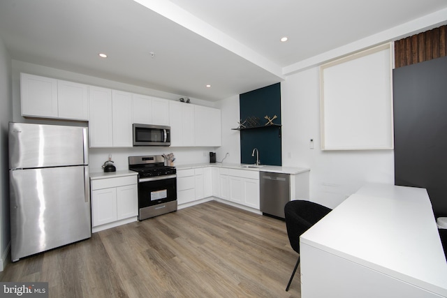 kitchen featuring sink, white cabinetry, stainless steel appliances, and light hardwood / wood-style floors