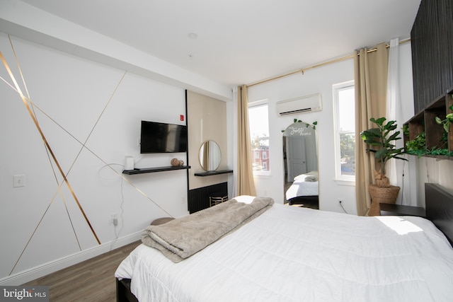 bedroom with a wall mounted air conditioner and dark hardwood / wood-style flooring