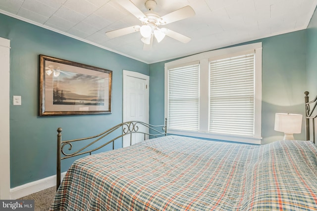 carpeted bedroom featuring ceiling fan and crown molding