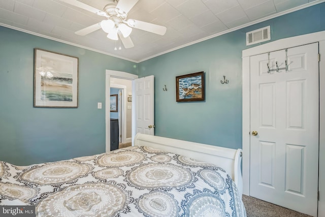 bedroom featuring a closet, ornamental molding, carpet, and ceiling fan