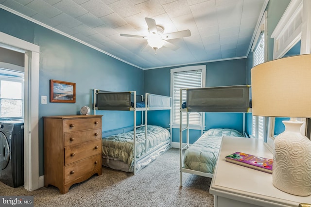 carpeted bedroom featuring ornamental molding, ceiling fan, multiple windows, and washer / clothes dryer